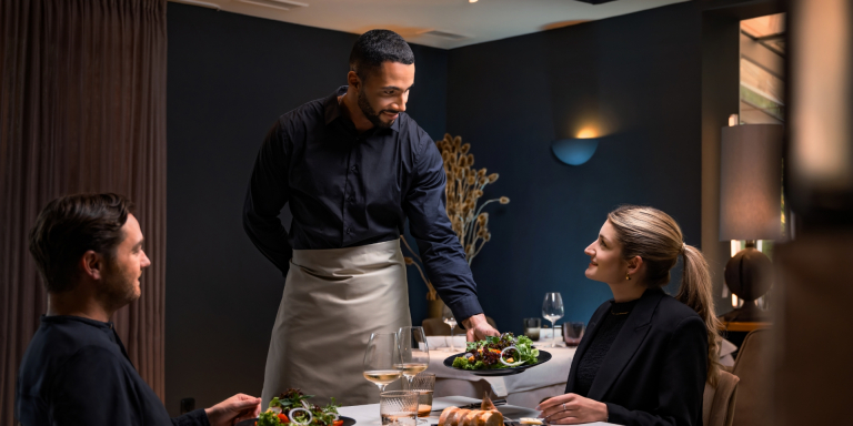 Kellner bringt Essen an den Tisch