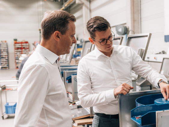 Zwei Männe rmit weißen Hemden in Fabrik