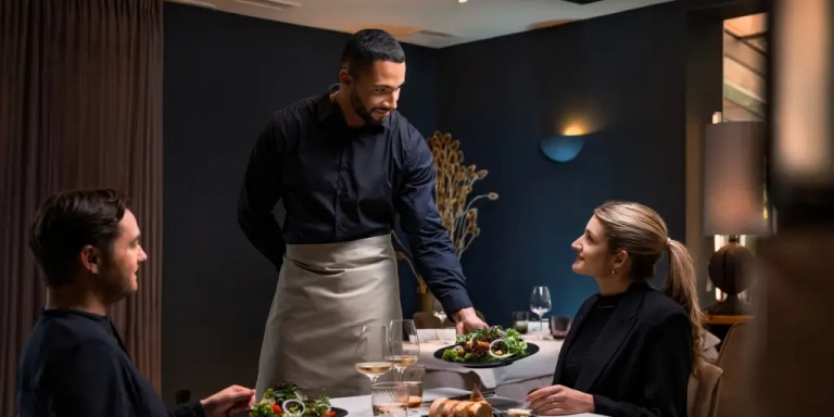 Kellner bringt Essen an den Tisch
