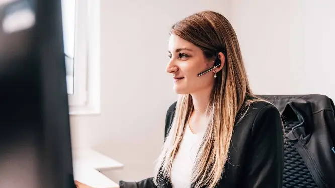 Frau mit Headset am Arbeitsplatz.
