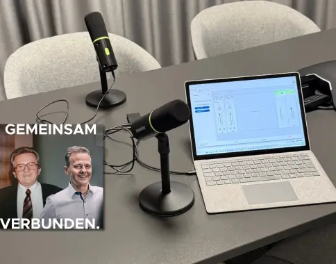 Bild von einem Tisch mit Laptop und zwei Stand Podcast Mikrofonen. Zudem ein Titelbild eines Podcasts.
