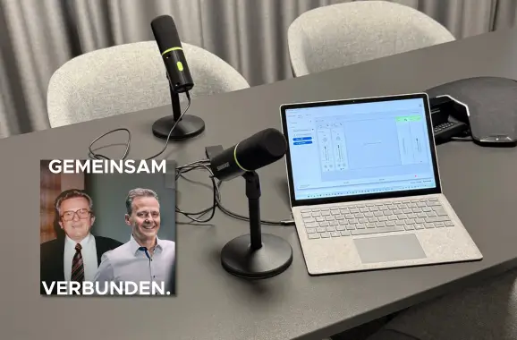 Bild von einem Tisch mit Laptop und zwei Stand Podcast Mikrofonen. Zudem ein Titelbild eines Podcasts.
